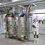 amixon® Malaxeur à deux arbres HM 2000 pour des charges de 2 m³. Le mélangeur repose sur des cellules de pesage et est équipé de deux trappes d'évacuation.